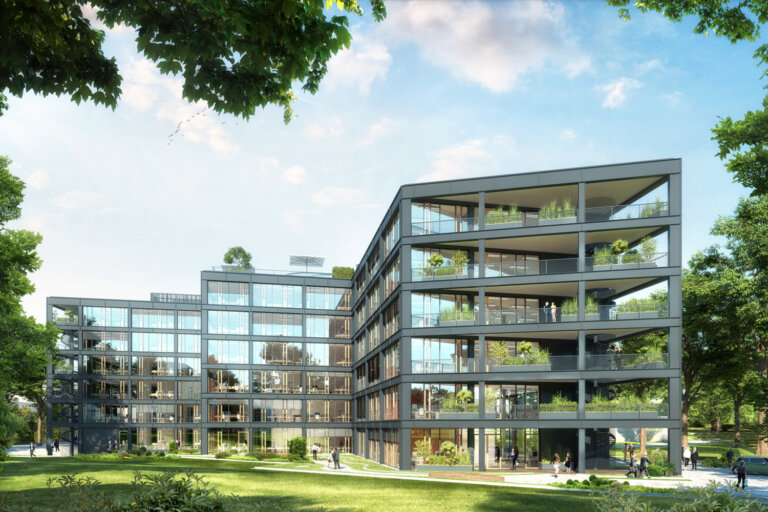 Das Bild zeigt das Bürogebäude Grasblau, wo nexnet sein neues Büro hat. Es ist ein nachhaltiges Gebäude, mit viel Glas in der Außenfassade und viel grün drum herum gepflanzt.