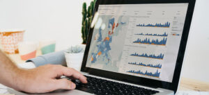 MRR reporting, left hand taps on laptop, graphic about reporting on screen