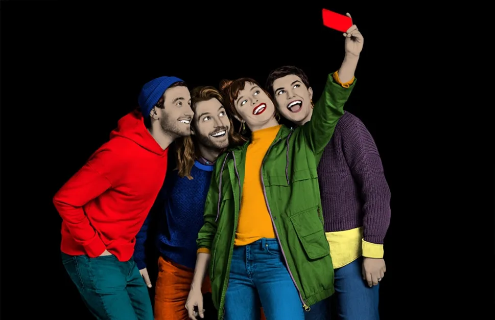 Vier junge Menschen in bunter Kleidung machen gemeinsam ein Selfie