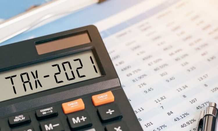 Taschenrechner im Vordergrund, Steuerunterlagen im Hintergrund