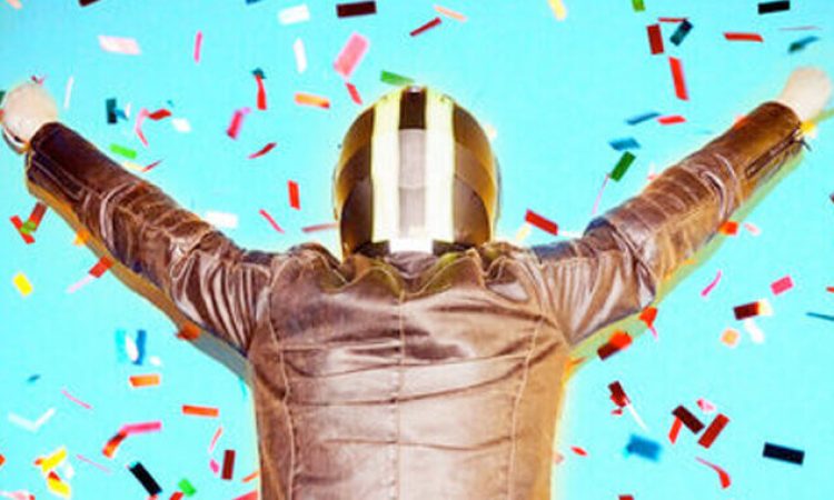 A person wearing a helmet and leather jacket can be seen from behind. She is standing in a shower of confetti.