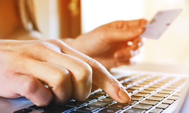 Close-up of a hand typing on the keyboard of a laptop.
